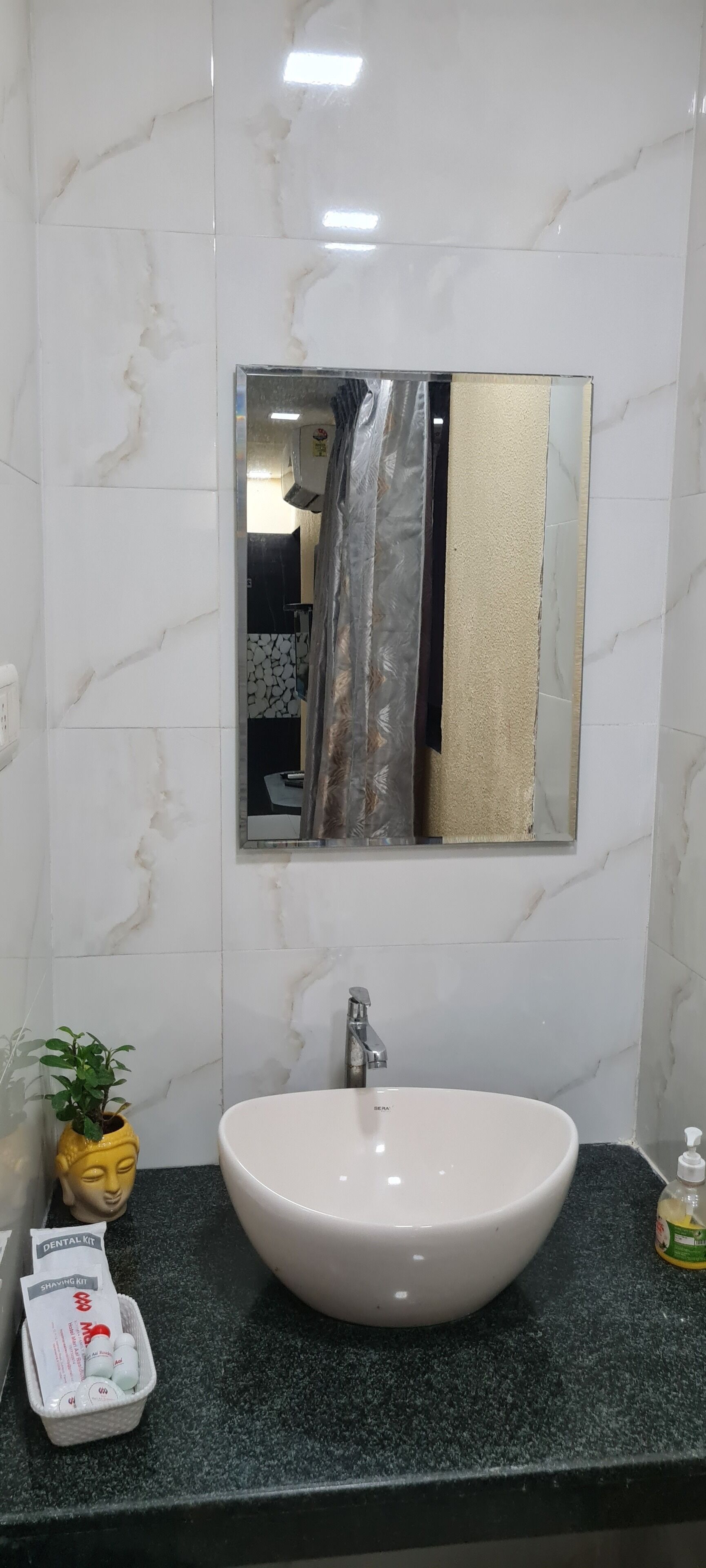 A bathroom with a white sink, a mirror, and a towel rack.
