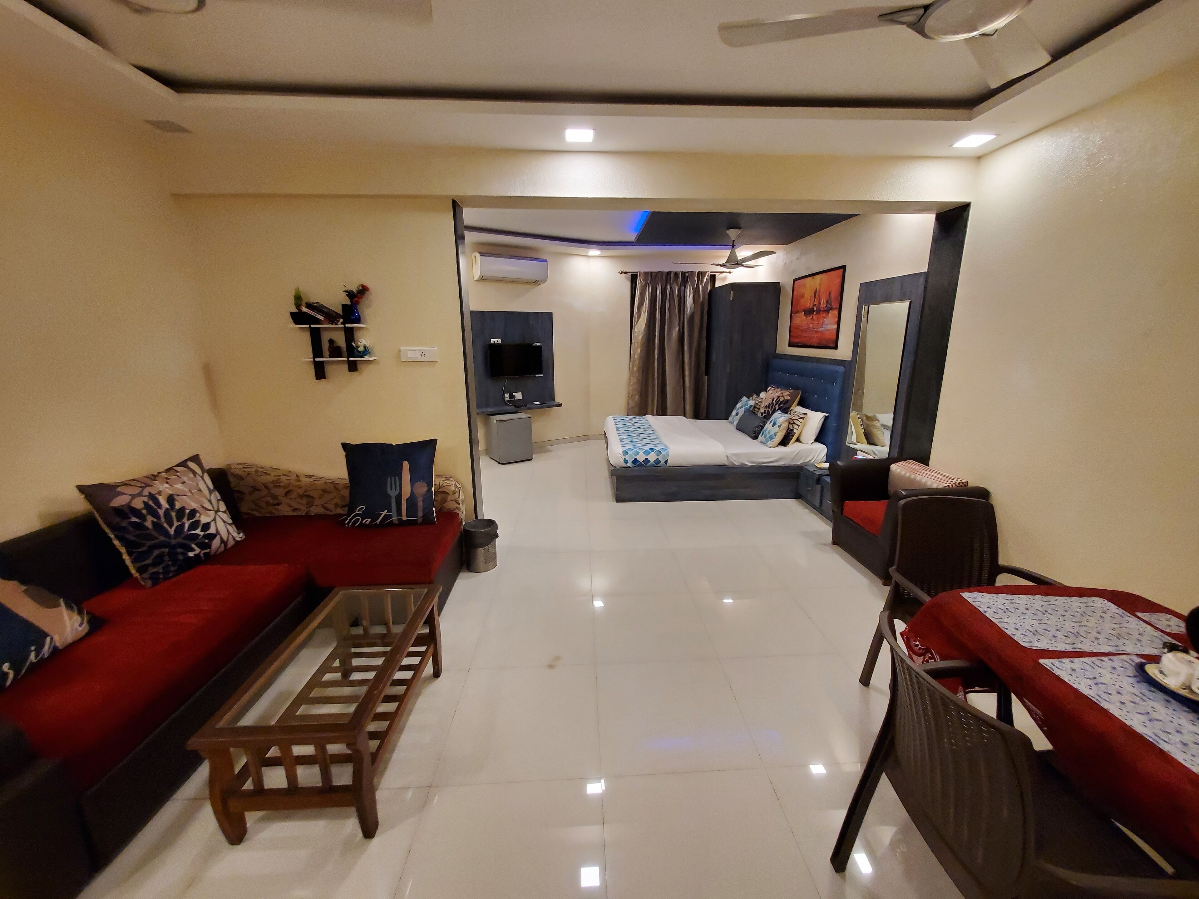 A modern living room with a sofa, a coffee table, and a dining area with a table and chairs.