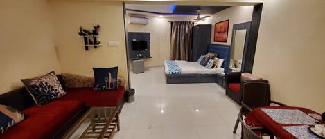A modern living room with a sofa, a coffee table, and a dining area with a table and chairs.