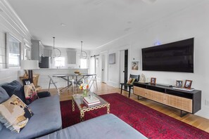A modern living room with a sofa, coffee table, and a flat-screen TV.