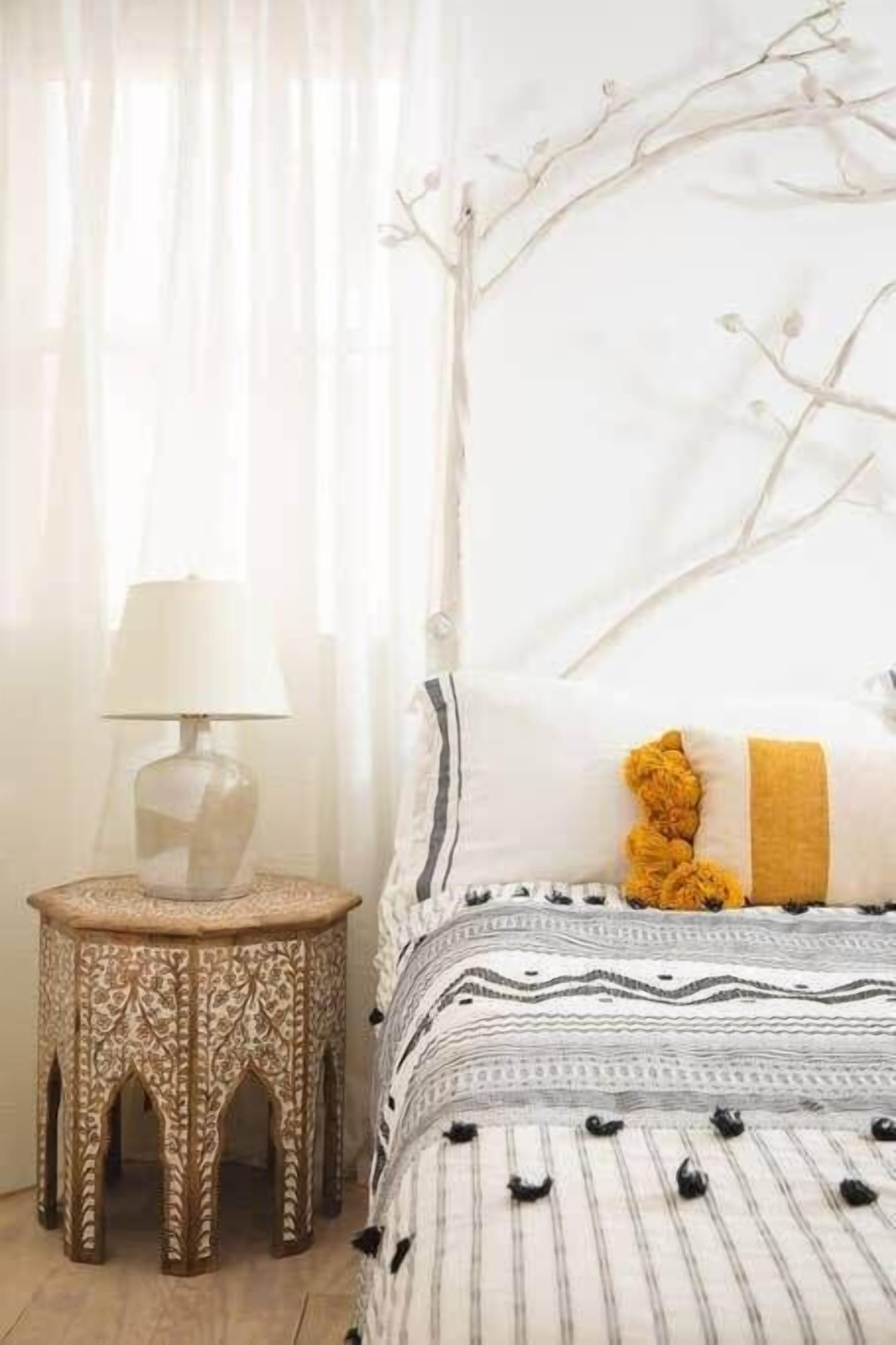 Une chambre à coucher avec un lit, une table de chevet et une lampe.