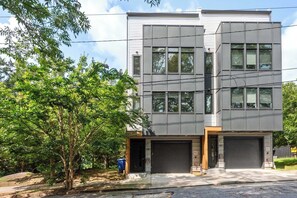 A modern two-story building with large windows and a garage.