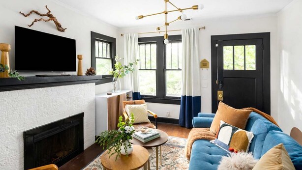 A living room with a fireplace, a television, and a blue sofa.
