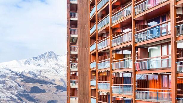 A multi-story hotel with balconies, set against a mountainous backdrop. - Studio in Center for 2, Free Wifi (Les Arcs 1800)