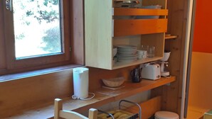 A kitchen with wooden cabinets, a window, and a sink. - Studio in Center for 2, Free Wifi (Les Arcs 1800)