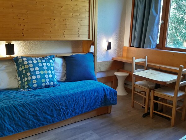 Une pièce confortable avec un lit, une petite table et des chaises.