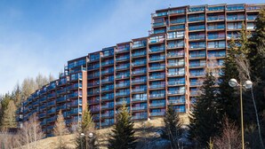 A multi-story building with numerous balconies, surrounded by trees and a clear sky. - Studio in Center for 2, Free Wifi (Les Arcs 1800)