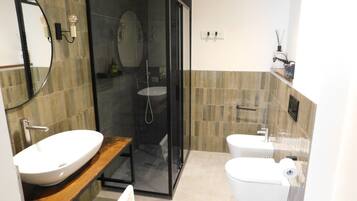 Une salle de bain moderne avec une douche en verre, un meuble-lavabo en bois, un lavabo blanc et des toilettes.