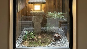 A traditional Japanese garden with a stone lantern, a small pond, and a wooden fence. - Shirakawa Seiryuan Bettei (Kyoto)