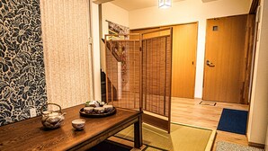 A traditional Japanese room with tatami flooring, a low wooden table with tea set, sliding shoji doors, and a wooden wardrobe. - Shirakawa Seiryuan (Kyoto)