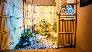 A traditional Japanese garden with bamboo fencing, a wooden gate, and a small rock garden. - Chiyonoya (Kyoto)