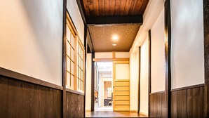 A narrow hallway with wooden paneling and a sloped ceiling. - Chiyonoya (Kyoto)