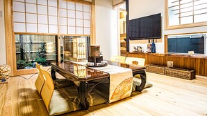 A traditional Japanese-style room with tatami flooring, a low table with cushions, and sliding doors. - Chiyonoya (Kyoto)
