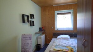 Una stanza accogliente e tranquilla con un letto, una scrivania e una finestra.