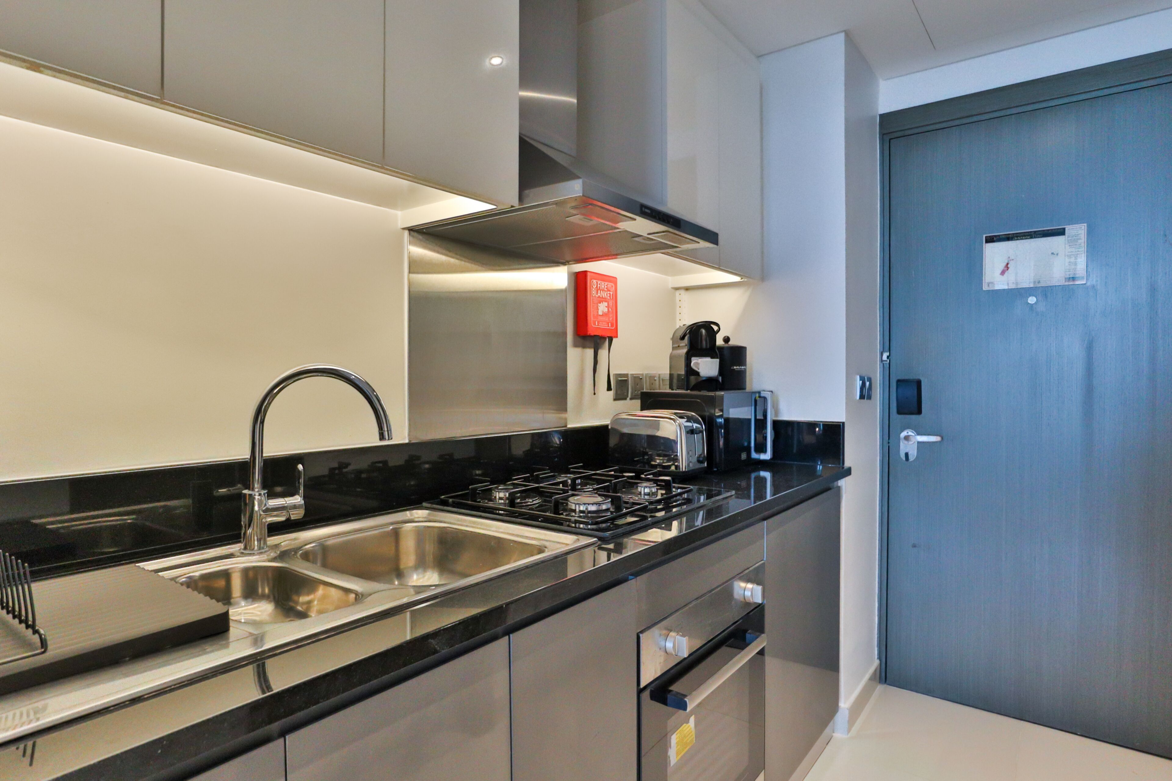 A modern kitchen with stainless steel appliances, a built-in oven, and a sink.