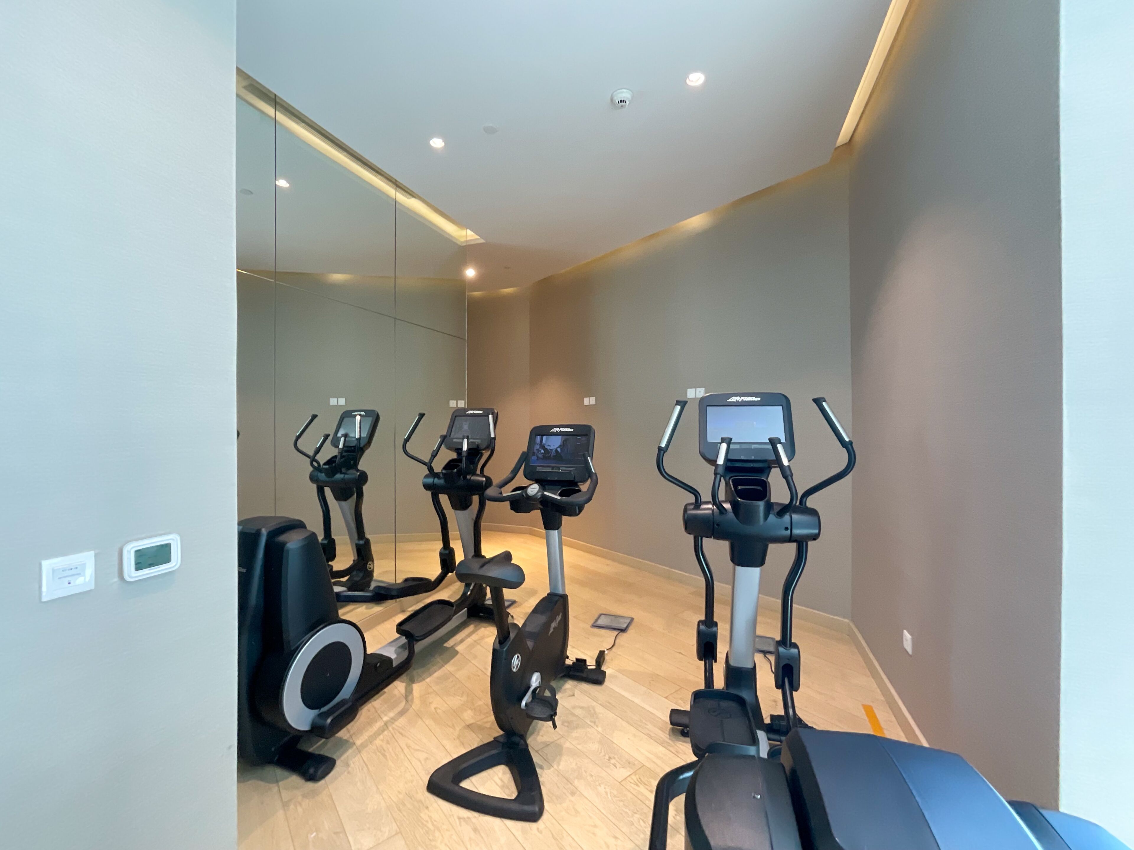 Een sportschool met vier hometrainers en een roeimachine.