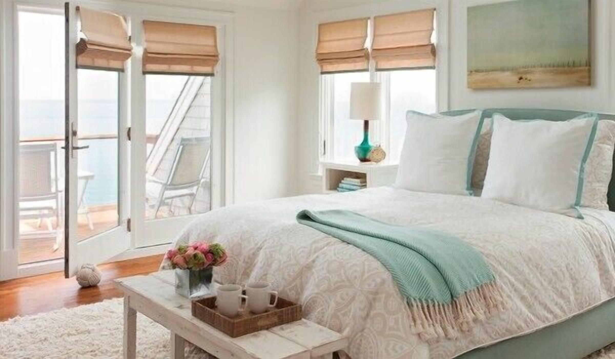 A bedroom with a large bed, a nightstand, a window with a view, and a balcony door.