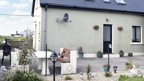 Un bâtiment doté d’un toit en pente, d’une antenne parabolique et d’une porte.
