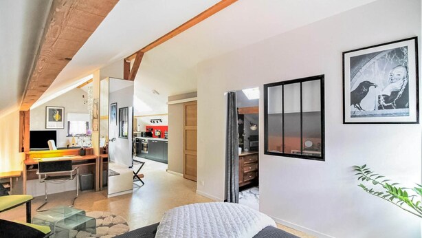 Un interior moderno con cama, escritorio y zona de cocina.