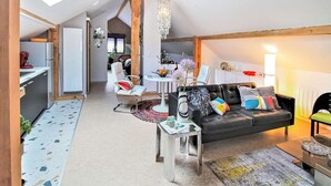 Un moderno espacio tipo loft con techo alto, comedor y cocina.