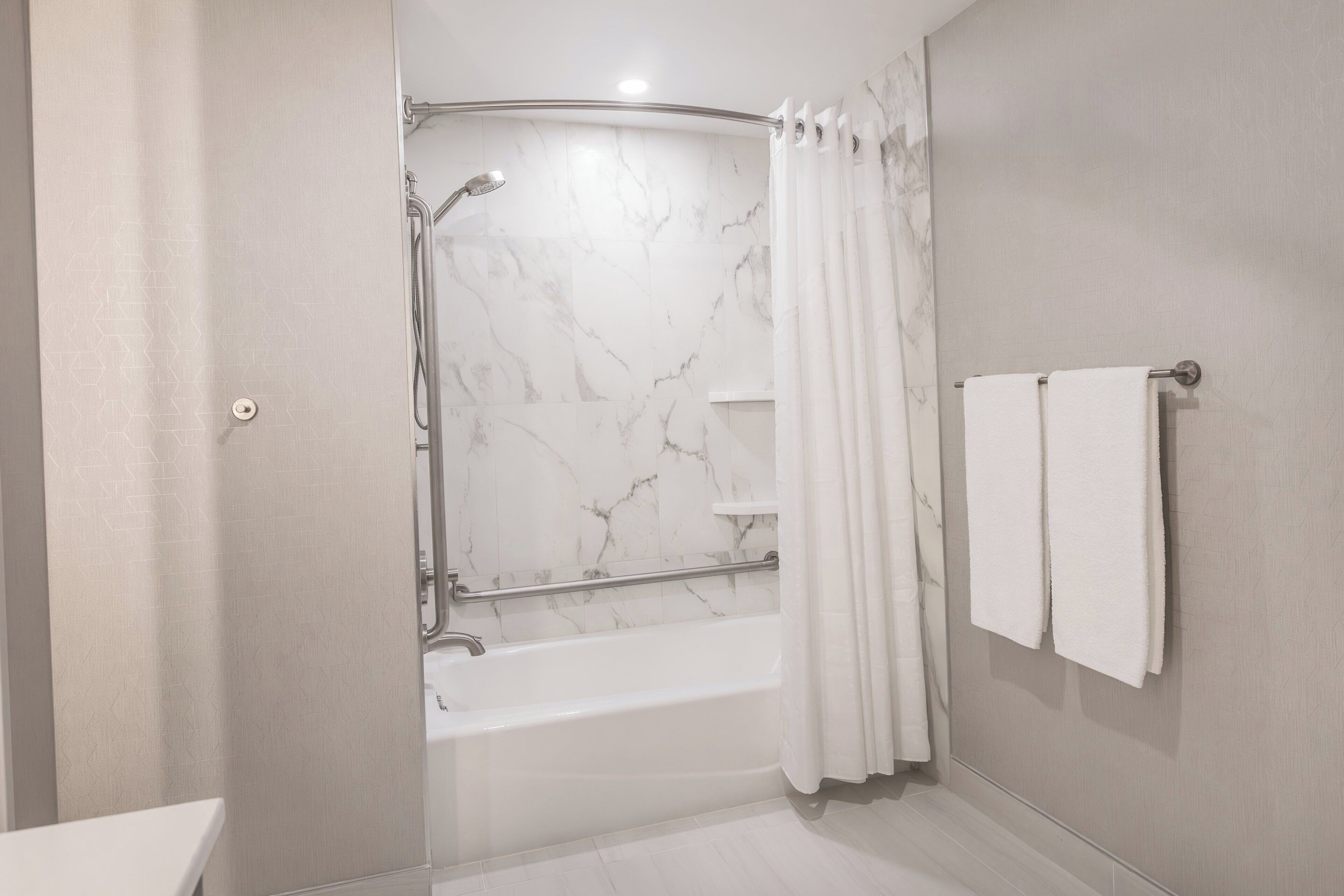 A modern bathroom with a shower, a bathtub, and a toilet.