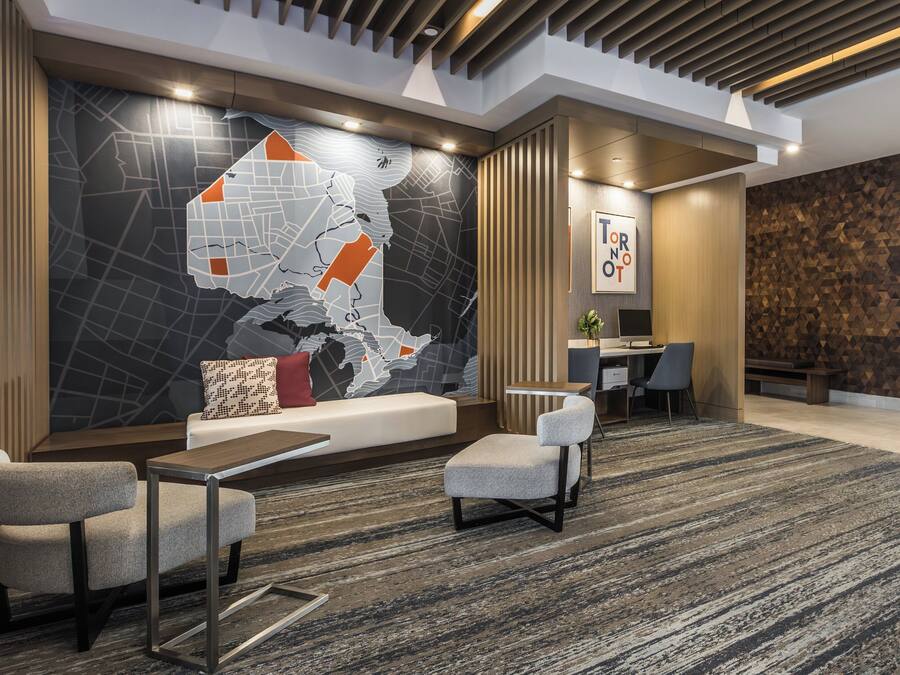 A modern lobby with a large map mural, seating area, and a wooden accent wall.