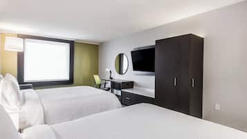 Une chambre d’hôtel avec deux lits, un bureau, une chaise, une télévision et une armoire.
