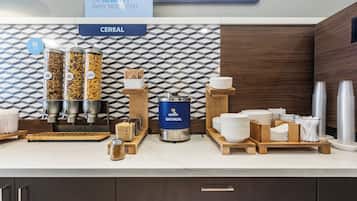 A breakfast bar with cereal dispensers, an oatmeal dispenser, and a sign asking "Healthy or Healty? Why not both".