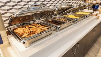 Un buffet proposant divers plats présentés dans des récipients en métal.