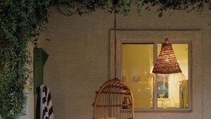 A wicker chair hanging from a ceiling, a wooden bench, and a window with a hanging light fixture. - 4 bedroom private home in Coronado Historic District by PHX Stays (Phoenix)