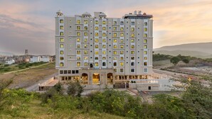 A multi-story hotel with a central courtyard, large windows, and a flat roof. - Paandora Grand Udaipur (Udaipur)
