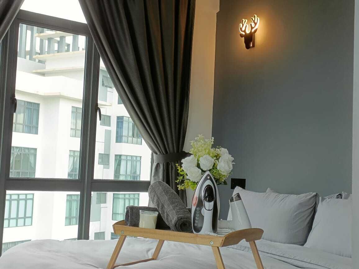Ein Hotelzimmer mit einem Bett, einem Nachttisch mit Bügeleisen, einer Vase mit Blumen und einer Wandleuchte.