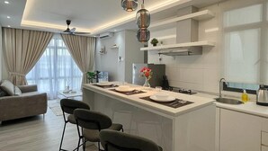 Una cocina moderna con una isla central, taburetes de bar e iluminación colgante.