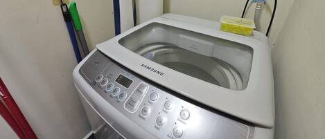 A Samsung washing machine with a transparent water tank, control panel, and a detergent compartment.