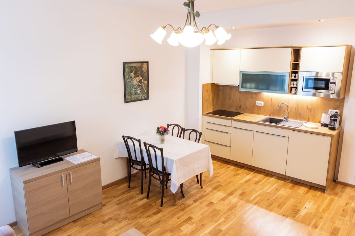 Una cocina funcional con microondas, lavamanos y armarios de madera.