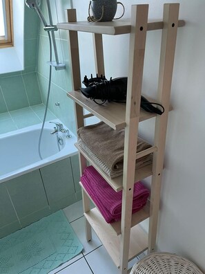 Tina con regadera, secadora de cabello, toallas, papel de baño