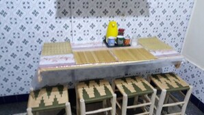 Uma área de refeições com uma mesa longa e quatro banquetas de madeira.