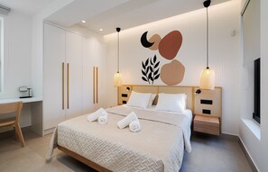 Ett modernt hotellrum med en stor säng, sängbord, ett skrivbord och en TV.