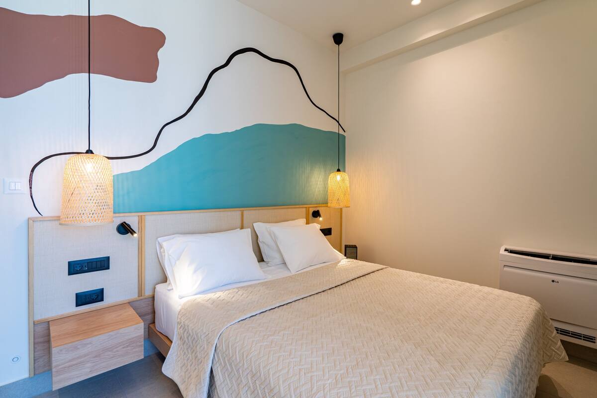 A modern bedroom with a bed, bedside lamps, a wall-mounted air conditioner, and a unique wall art design.