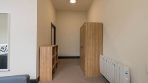 En smal hall med ett element, en trägarderob och en hyllsektion.