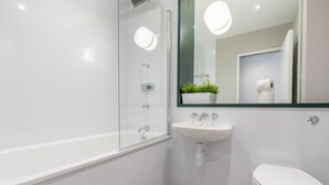 A modern bathroom with a glass shower enclosure, a white sink, and a toilet. - JOIVY Meadows Park Ensuite Single Room (Edinburgh)