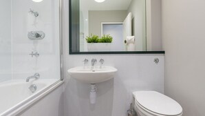 A modern bathroom with a white sink, a toilet, and a glass shower enclosure. - JOIVY Meadows Park Ensuite Single Room (Edinburgh)
