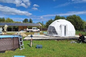 A large white dome structure, a truck, and a solar panel array in a grassy area. - 2brcabin-fireplace-hottub-sauna-skiresort (Bran)