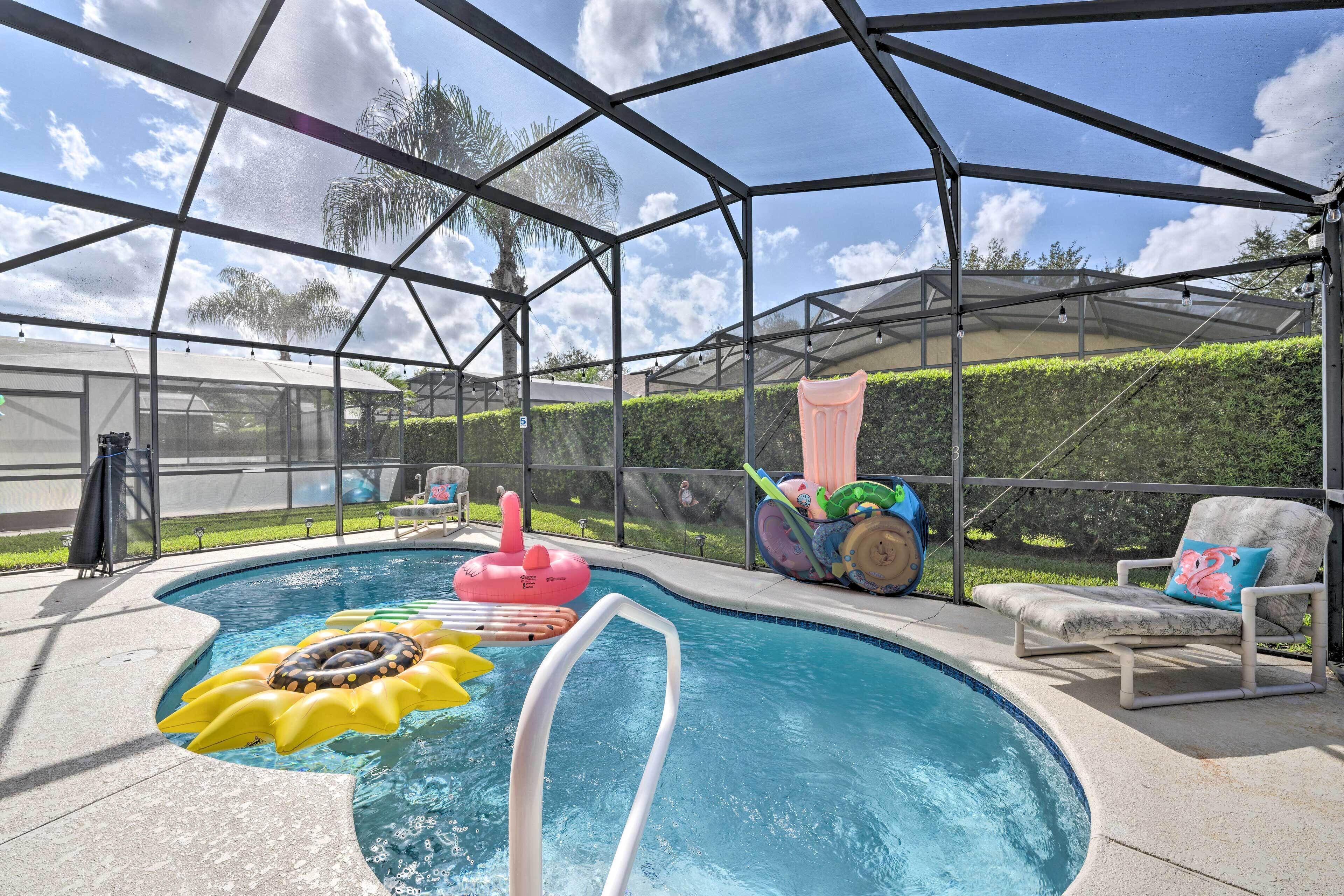 Ein überdachter Pool mit aufblasbaren Spielzeugen, einer Liege und Blick auf die umliegende Landschaft.