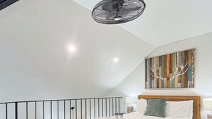 A bedroom with a bed, a ceiling fan, a cowhide rug, and a wooden headboard. - Walk to Ski | Hot Tub | Great Location (Park City)