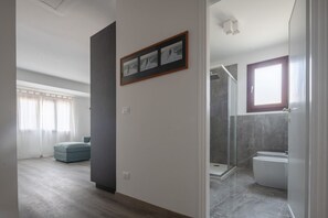 A modern bathroom with a glass shower, a toilet, and a window. - Bright Apartment On Venetian Roofs R&R (Santa Croce)