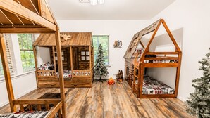 A room with two wooden bunk beds, a small Christmas tree, and a decorative wall piece. - The Fawn Château w/ Game Room & sauna  (Lake Ariel)