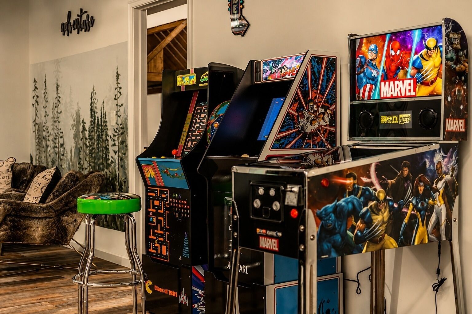 A room with arcade games, including a Spider-Man themed machine, and a bar area with stools.