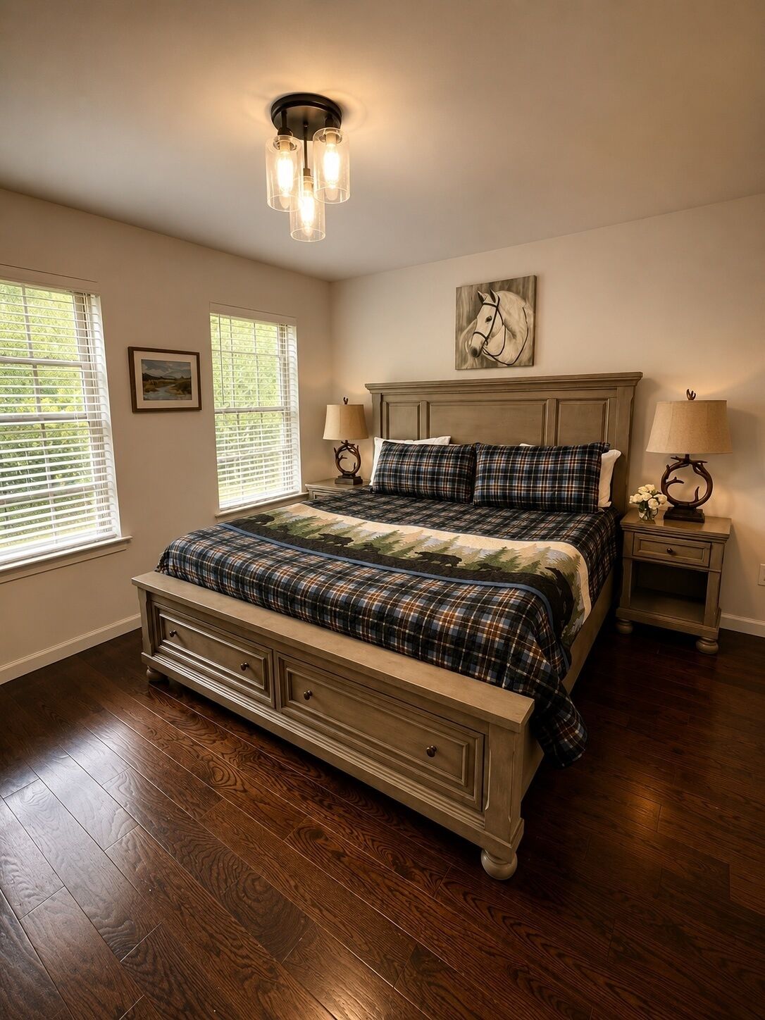 A bedroom with a large bed, two bedside tables, a headboard, and a ceiling light fixture.