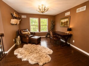 A room with a fireplace, a dining table, and a large window. - The Fawn Château w/ Game Room & sauna  (Lake Ariel)